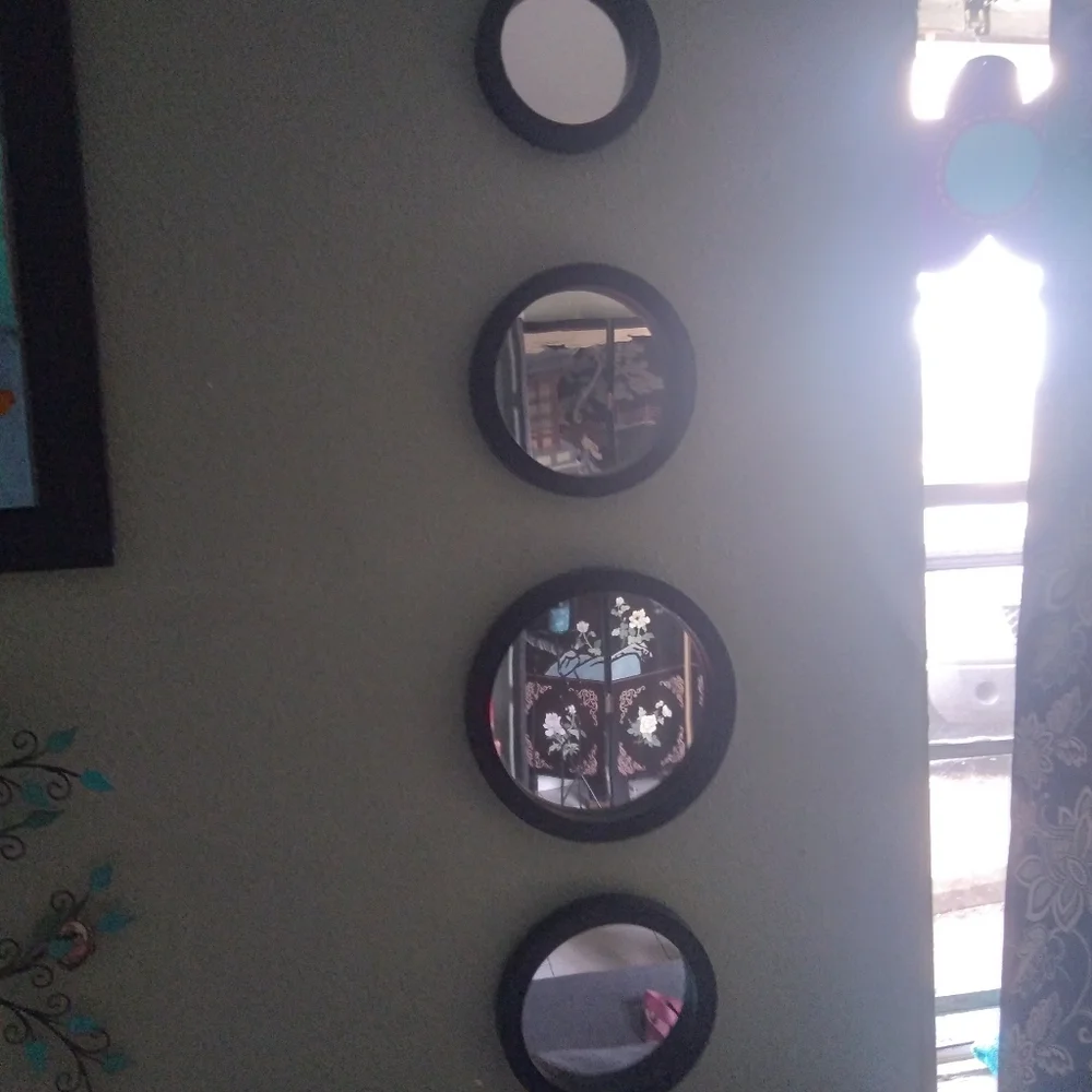 Four black round wall mirrors